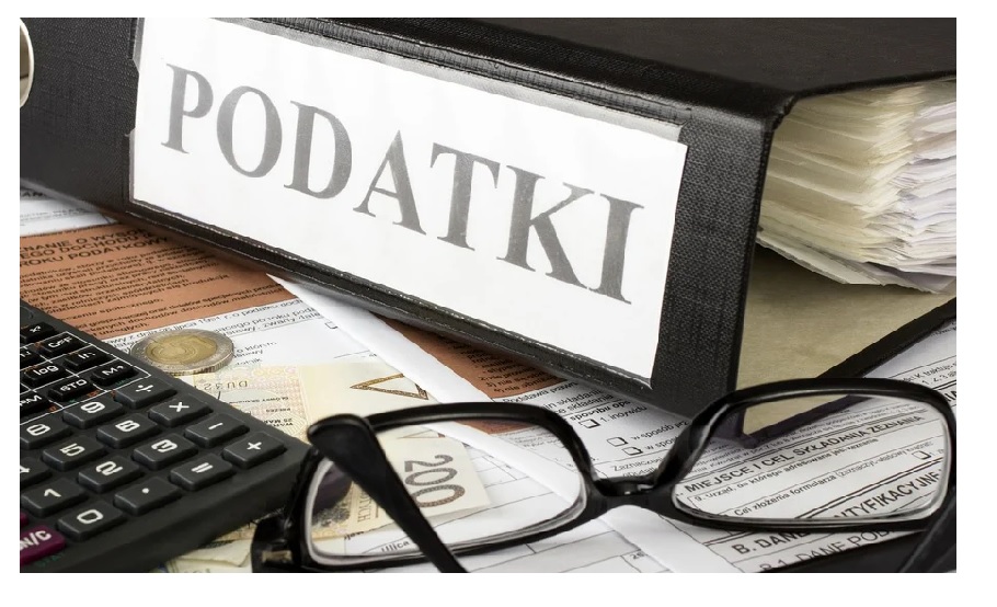 na zdjęciu segregator z napisem podatki, okulary i kalkulator