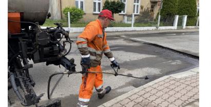 Drogowiec nakładający warstwę ścieralną asfaltu na ulicy Łąkowej