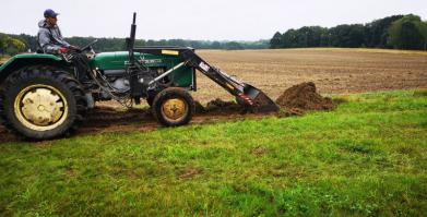 Traktor ze spychem zrywajacym darń pod nasadzenia