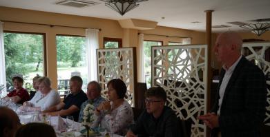 Uczestnicy spotkania przy stole w restauracji, Burmistrz przemawia