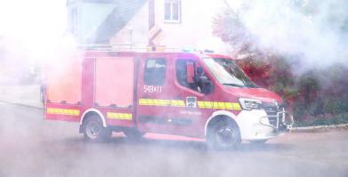 Samochód OSP Barwice wjeżdża na tle palących się rac