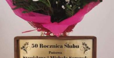 na zdjęciu filiżanki w ozdobnym pudełku jako prezent dla Państwa Sarapuk oraz bukiet kwiatów dla Jubilatów