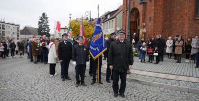 na zdjęciu poczty sztandarowe OSP oraz delegacje składające kwiaty pod pomnikiem na Placu Wolności