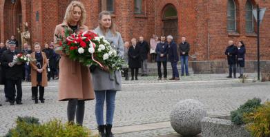 na zdjęciu Delegacja Niepublicznego Przedszkola angielsko-polskiego "Happy Land" składająca kwiaty pod pomnikiem